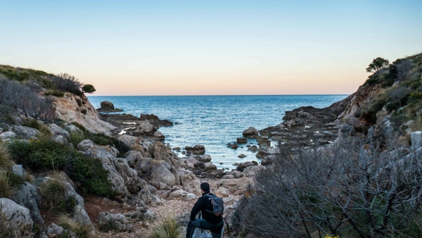 Wanderer auf sardinien am strand mit blick aufs meer mit tagesrucksack