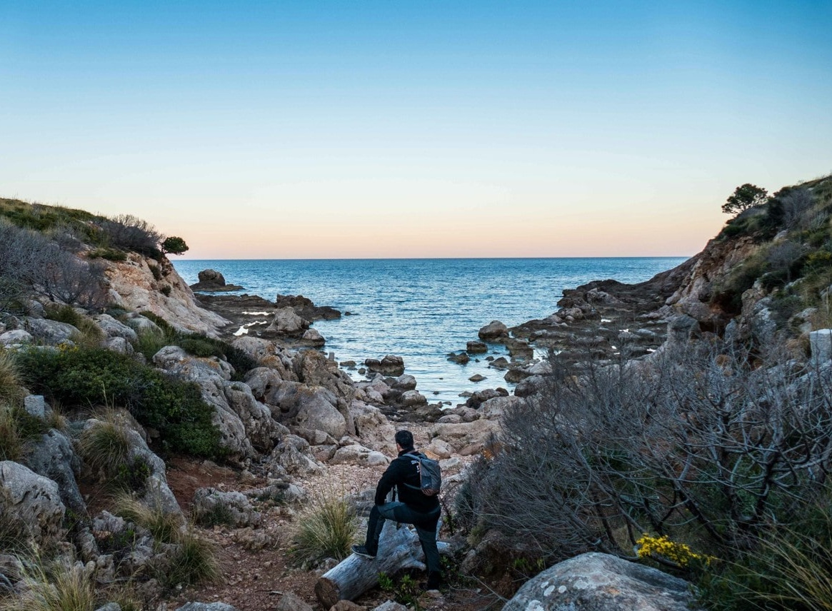 Wanderer auf sardinien am strand mit blick aufs meer mit tagesrucksack